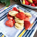 Crispy freeze-dried strawberry and banana fruit slices served on a dining cloth napkin